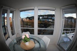 a dining room with a glass table and two windows at APARTAMENTOS URDAIBAI 5 in Bermeo