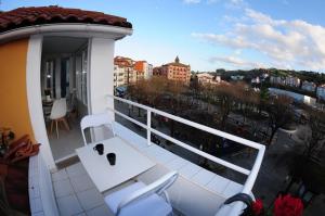 a balcony with a white table and chairs on a balcony at APARTAMENTOS URDAIBAI 5 in Bermeo