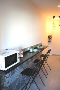a kitchen with a counter with chairs and a microwave at Pigneto7 in Rome