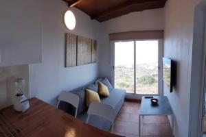 sala de estar con sofá azul y mesa en Casita con Encanto, en La Frontera