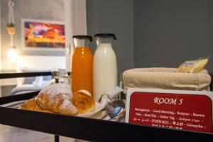 a tray with a plate of pastries and bottles of milk at Piccolo Hotel Boutique in Rome