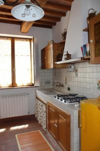 a kitchen with a stove and a yellow refrigerator at Agriturismo Fonteverdi in Boccheggiano