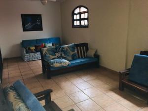 a living room with a blue couch and two chairs at Pousada Ilha Vitoria in Ubatuba
