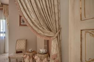 a curtain in a room with a chair and a table at Florence Dream Domus in Florence