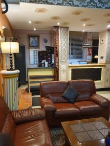 a living room with a leather couch and a bar at Ambassy Hotel in Kenitra