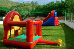 a play set in the grass in a backyard at Hotel Montanhes in Miguel Pereira