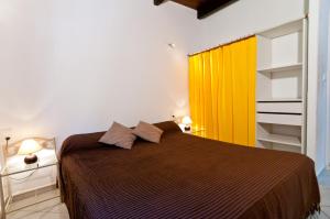 a bedroom with a bed and a yellow curtain at Villa Les Lieges de Palombaggia in Porto-Vecchio