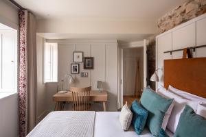 1 dormitorio con cama con almohadas azules y escritorio en Cheval Abbey Strand Apartments, at Holyrood en Edimburgo