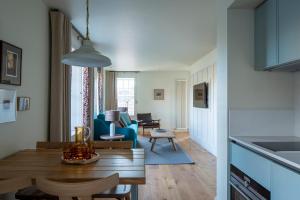 a kitchen and living room with a table and chairs at Abbey Strand Apartments, at Holyrood in Edinburgh