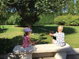 twee kinderen op een stenen bank in een park bij Casa San Marco in Castelnuovo del Garda