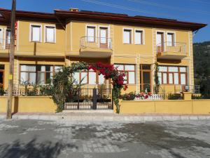 a yellow house with flowers in front of it at Sirman Apart Hotel in Sarigerme
