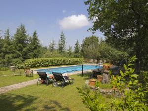 einen Garten mit Stühlen und einem Pool in der Unterkunft Belvilla by OYO Villa Ulivo in Radda in Chianti