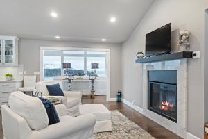 a living room with white furniture and a fireplace at Lakeview Luxury in Hope