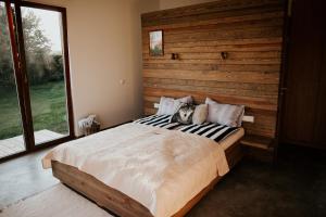 a bedroom with a large bed with a wooden wall at Magnolia Park in Engure