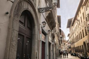 an alley with people walking down a street next to buildings at Florence Dream Domus in Florence