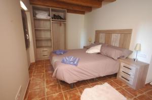 een slaapkamer met een groot bed met een houten hoofdeinde bij Torre del mig in La Seu d'Urgell