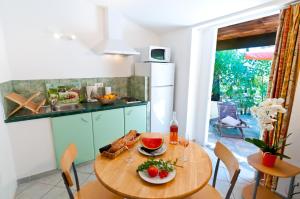 a kitchen with a wooden table with food on it at Villa Les Lieges de Palombaggia in Porto-Vecchio +16 photos