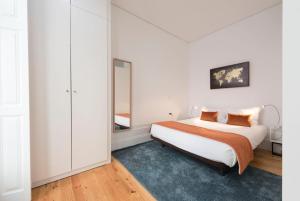 Habitación blanca con cama y espejo en Apartment Alegria Street by Sweet Porto - Free Parking, en Oporto