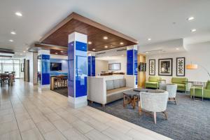 a lobby of a hotel with tables and chairs at Holiday Inn Express & Suites - Denton South, an IHG Hotel in Denton