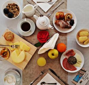 stół z talerzami jedzenia i kubkami kawy w obiekcie Le Undici Rose Hotel w mieście Viterbo
