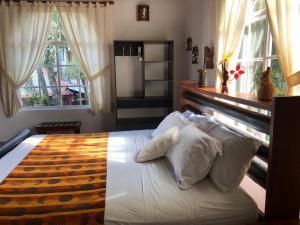 a bedroom with a large bed with white pillows at Hotel Puerto Gaviota in Tonsupa