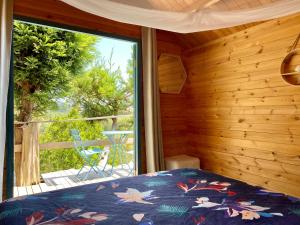 a bedroom with a bed and a view of a balcony at Tui Ridge Eco Cabins in Aongatete