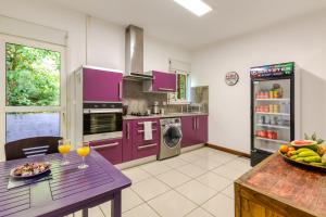 a kitchen with purple cabinets and a table with wine glasses at Tipalais in Saint-Pierre
