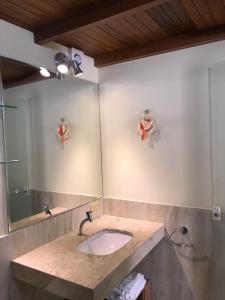 een badkamer met een wastafel en een spiegel bij Casa Maury in Lauro de Freitas