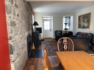 ein Wohnzimmer mit einem Tisch und einer Steinmauer in der Unterkunft Artillery view Condo (free parking) in Québec