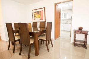 comedor con mesa de madera y sillas en San Fernando Suite 202 - Livin Colombia, en Cali