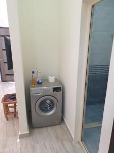 a washing machine in a room with a shower at Bravey Apartments in Hurghada