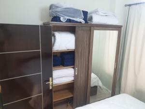a wooden cabinet with a mirror and towels at Bravey Apartments in Hurghada