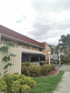 a building with a fence in front of it at Central Motel Ipswich in Ipswich