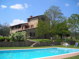 an old house with a swimming pool in front of it at Agriturismo Casagrande in Montepulciano