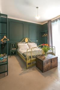 モンフォルテ・ダルバにあるRelax in Langaの緑のベッドルーム(ベッド1台、木製テーブル付)