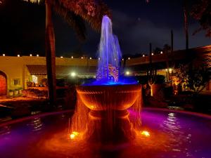 une fontaine éclairée par des lumières bleues et violettes dans l'établissement Hacienda de los Santos, à Álamos