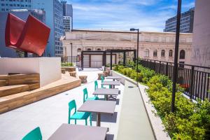 eine Dachterrasse mit Tischen und Stühlen und ein Gebäude in der Unterkunft Studio Central prox a Rua XV de Novembro - ALL1311 in Curitiba