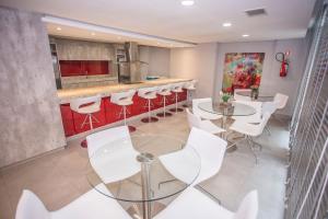 a dining room with white tables and white chairs at Apartamento 1 Quarto no Seventh Avenue - SEV1206 in Curitiba