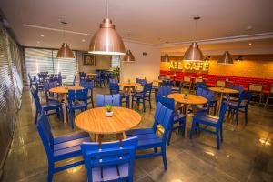 un restaurante con mesas de madera y sillas azules en Studio Central prox a Rua XV de Novembro - ALL1311, en Curitiba