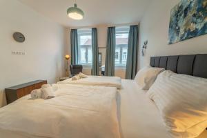 two beds in a bedroom with white sheets at josef's home I Maxi Apartment I near UNO, VIC in Vienna