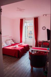 two beds in a room with red curtains at Relais Cola Di Rienzo in Rome