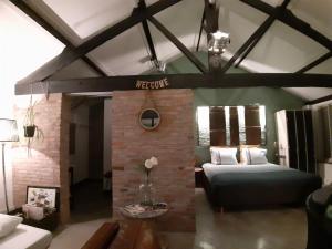 uma sala de estar com um sofá e uma lareira de tijolos em B&B LoFt 21 em Ravels