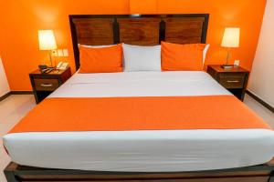 a bedroom with a bed and a night stand at Comfort Inn Cancún Aeropuerto in Cancún