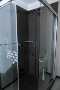 a bathroom with a glass door and a shower stall at Comfort Inn Cancún Aeropuerto in Cancún