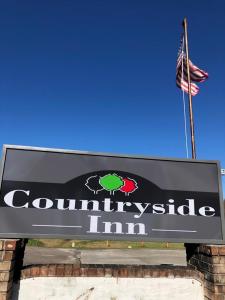 una señal para un edificio con bandera americana en Countryside Inn, en Harleyville