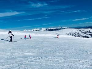 un grupo de personas esquiando por una pista cubierta de nieve en Lachtalhaus, en Lachtal