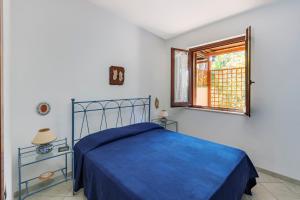 a bedroom with a blue bed and a window at VILLA GIAGGIA - VICINO IL MARE in San Vito lo Capo