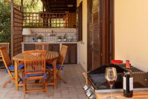Un patio con mesa y sillas y una botella de vino. en VILLA GIAGGIA - VICINO IL MARE, en San Vito lo Capo 24 fotos más