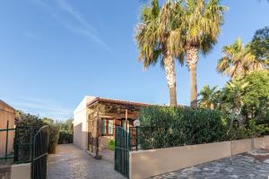 una casa con una puerta y palmeras en VILLA GIAGGIA - VICINO IL MARE, en San Vito lo Capo