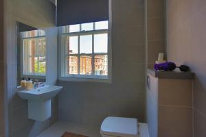 a bathroom with a sink and a toilet and a window at Spacesavers in Sheffield